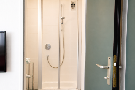 Badezimmer Nr. 8 Dusche mit gläserner Kabine und moderner Armatur, Tür offen.