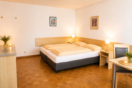 Zimmer 7 Helles, modernes Hotelzimmer mit Doppelbett, Tisch und gemütlicher Atmosphäre.